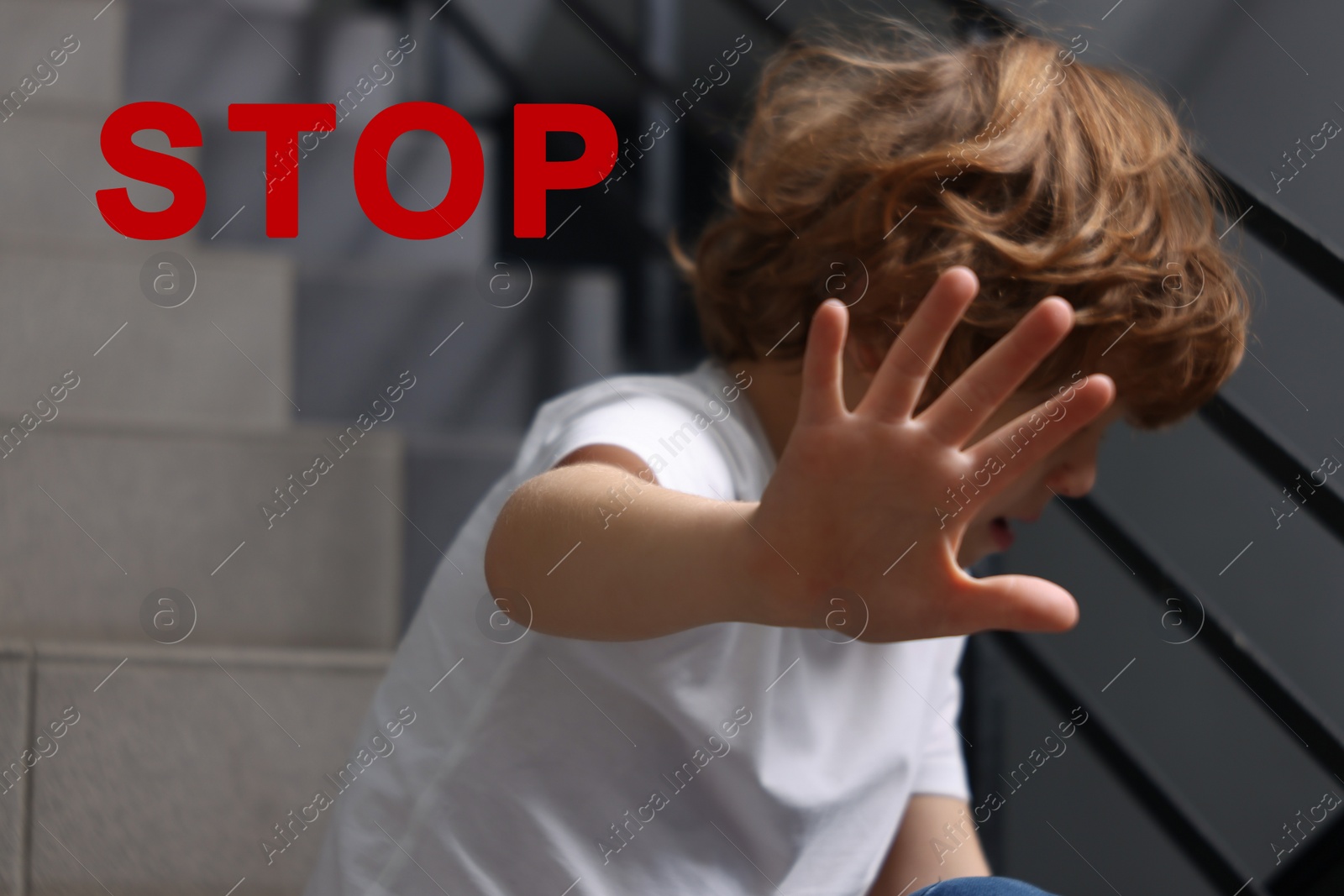 Image of No child abuse. Boy making stop gesture sitting on stairs, selective focus