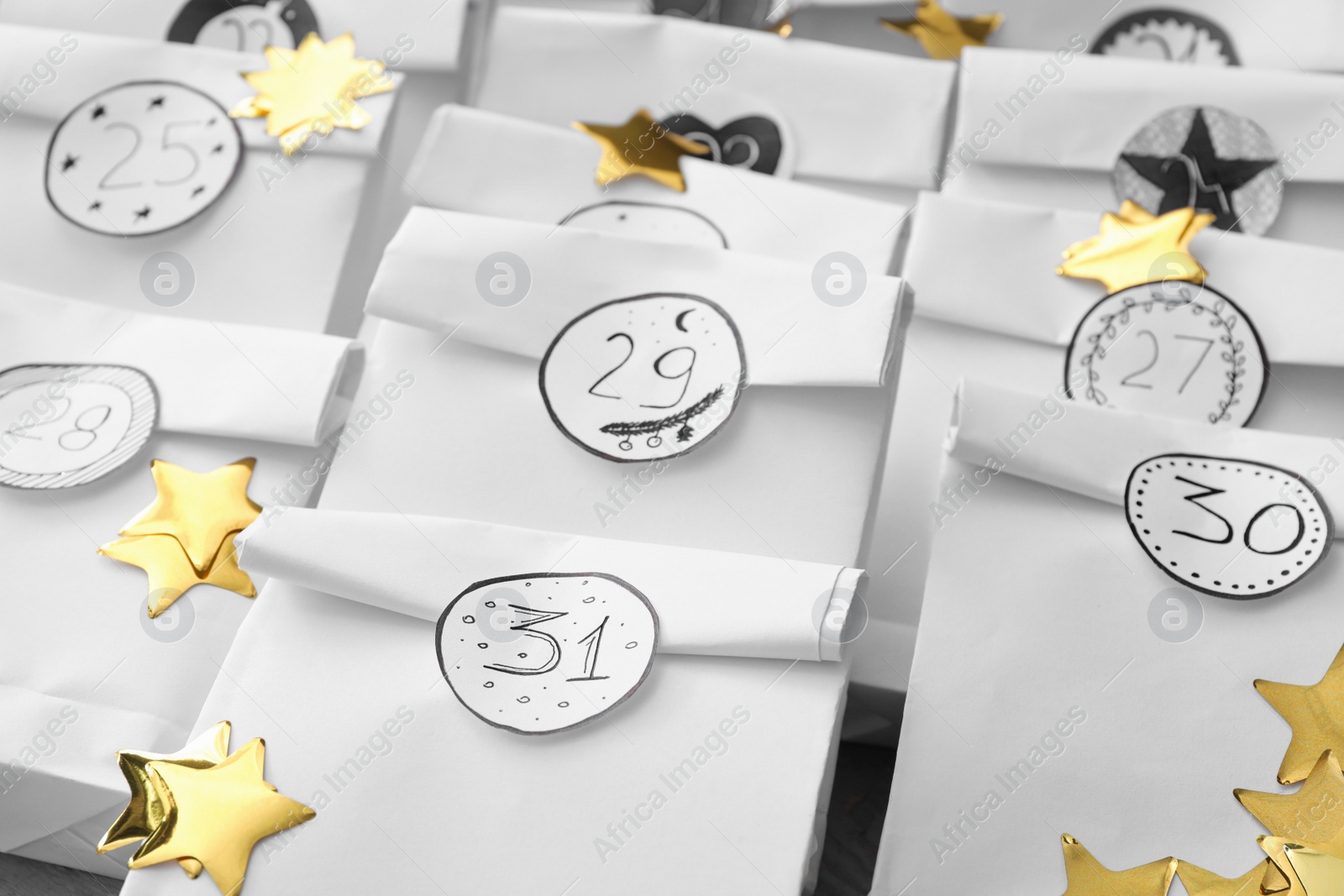 Photo of Christmas advent calendar with gifts on table, closeup