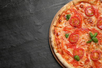 Photo of Delicious pizza Margherita on dark grey table, top view. Space for text