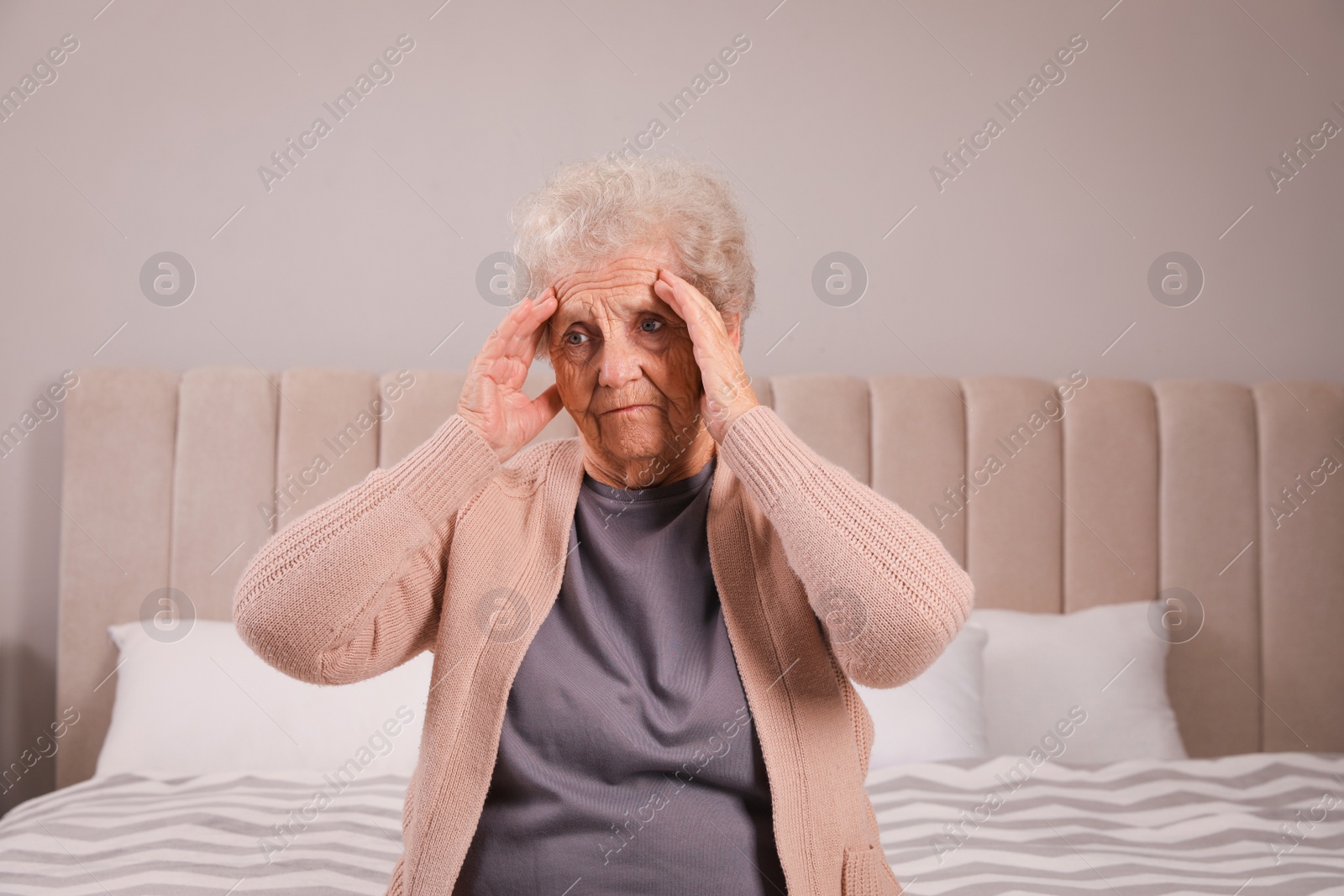 Photo of Senior woman with headache in bedroom at home