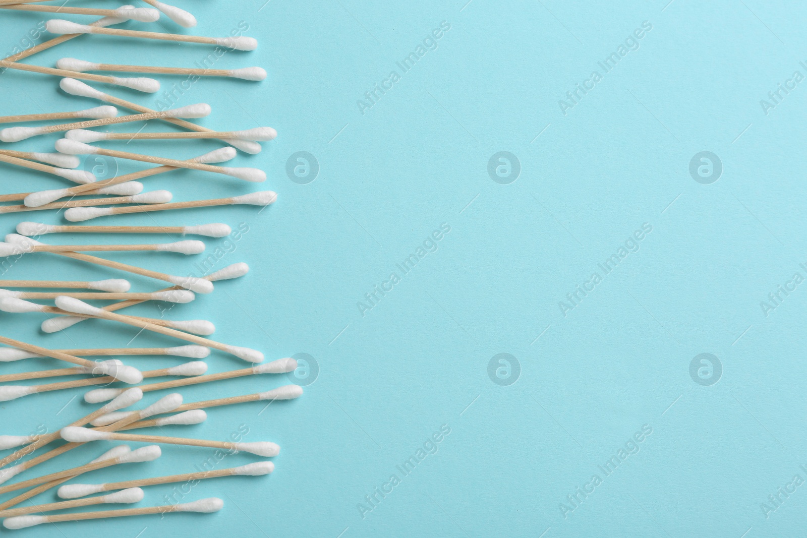 Photo of Flat lay composition with cotton swabs and space for text on color background