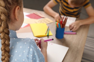 Children making beautiful greeting cards at table indoors, closeup