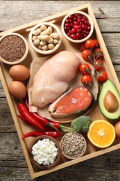 Photo of Tray with many different healthy food on wooden table, top view