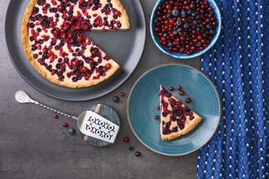 Photo of Delicious currant pie and fresh berries on grey table, flat lay