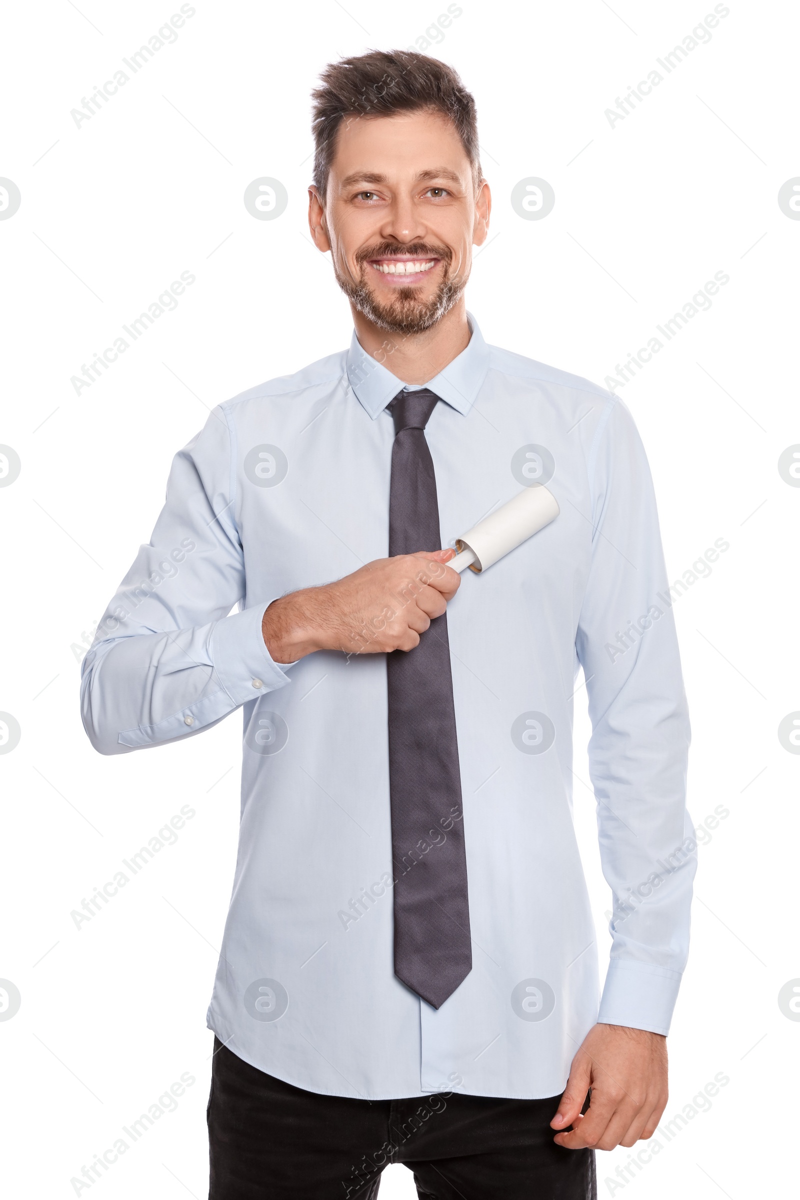 Photo of Handsome man cleaning shirt with adhesive lint roller on white background