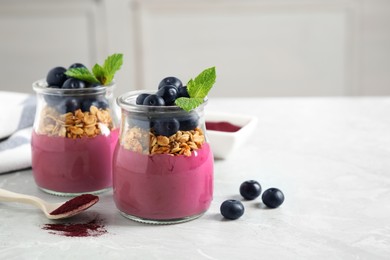 Image of Tasty dessert with acai smoothie, granola and berries on marble table. Space for text