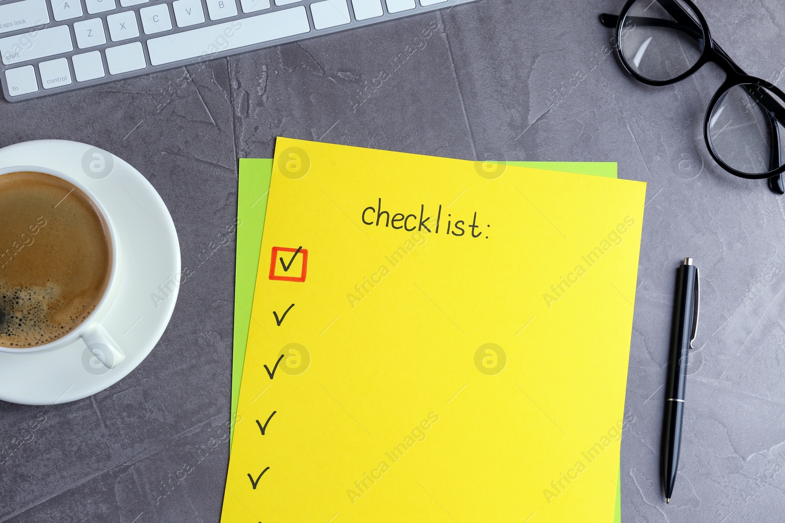 Photo of Paper sheet with inscription Checklist near eyeglasses, computer keyboard and cup of coffee on grey table, flat lay