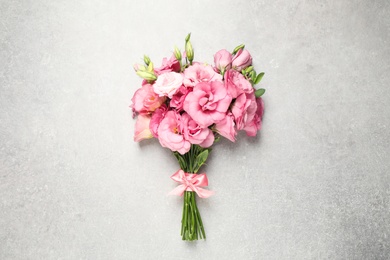 Photo of Beautiful bouquet of pink Eustoma flowers on light grey background, top view
