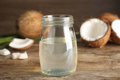 Photo of Coconut oil on wooden table, closeup view