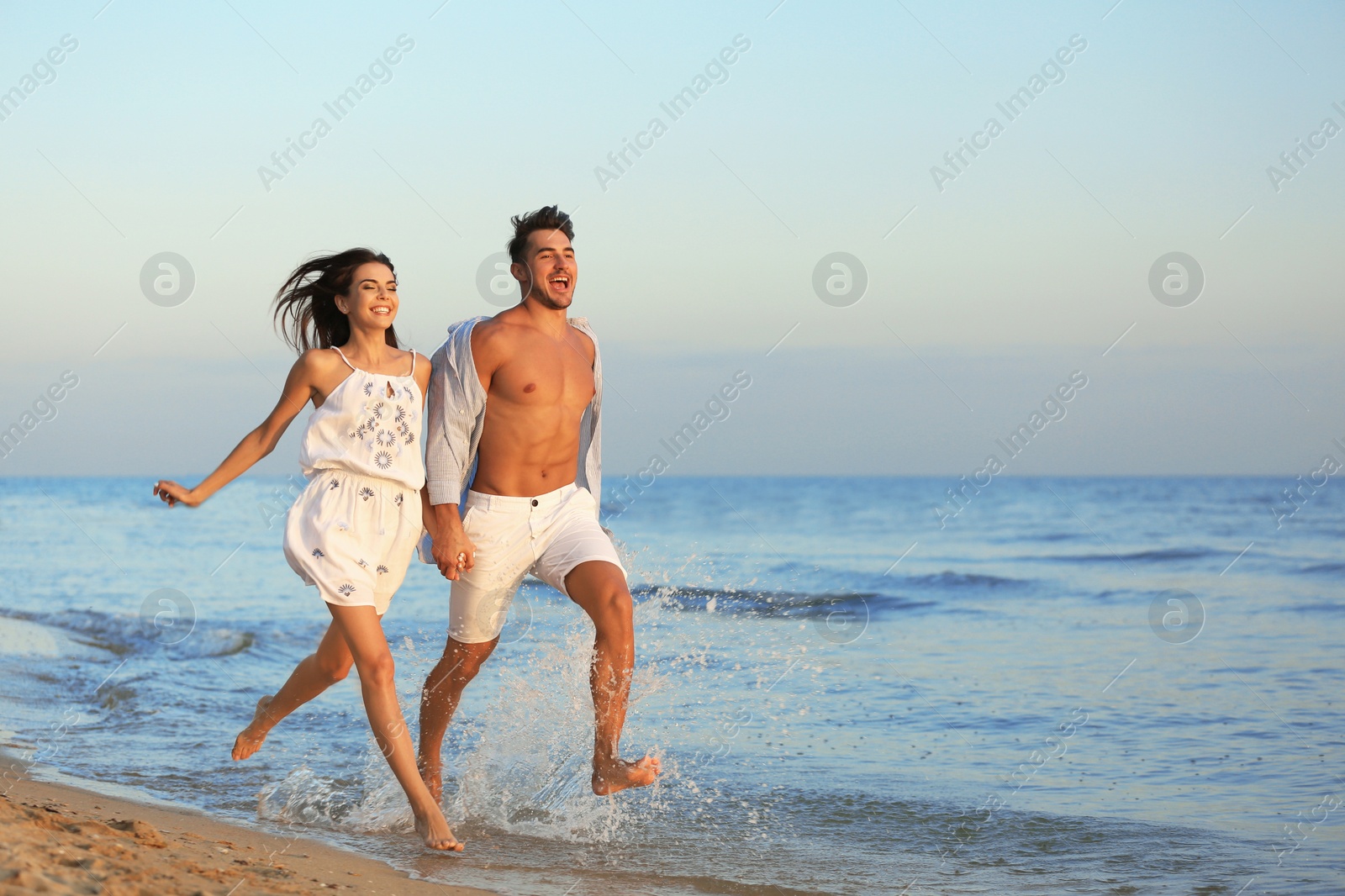 Photo of Happy young couple having fun at beach on sunny day