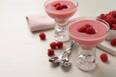 Delicious raspberry mousse on white wooden table, space for text