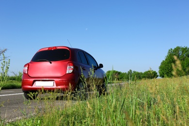 Photo of Modern color family car on highway. Space for text