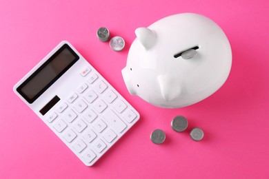 Photo of Financial savings. Piggy bank, coins and calculator on pink background, flat lay