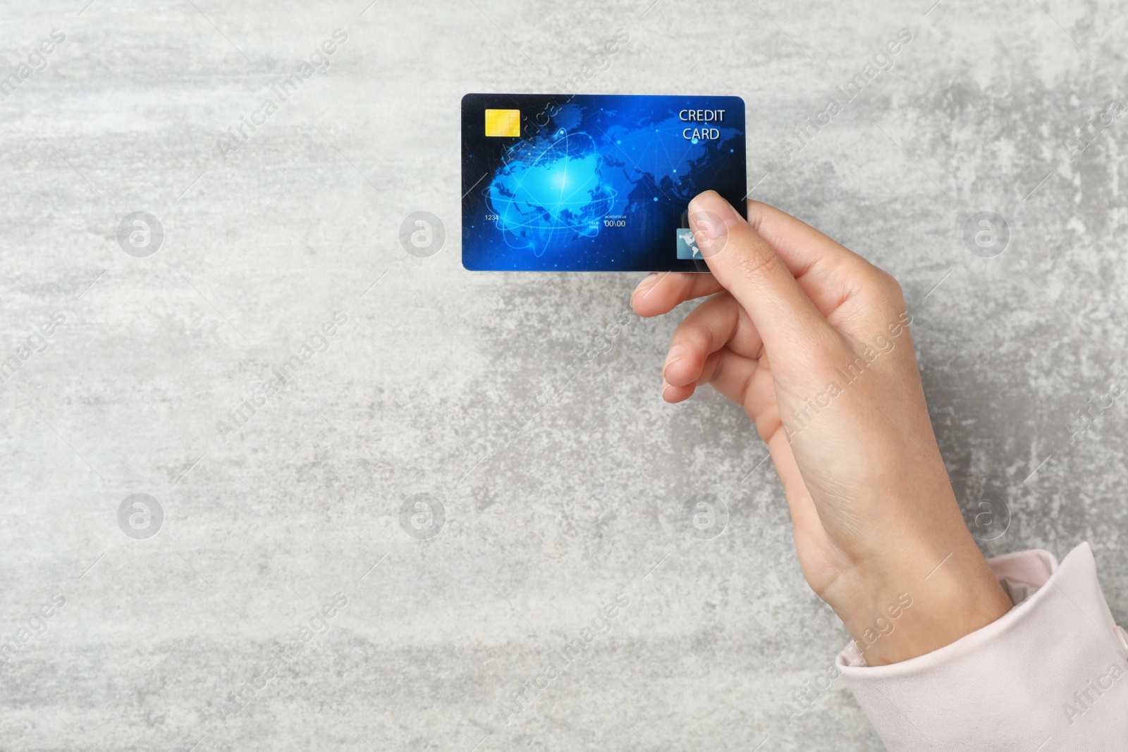 Photo of Young woman holding credit card over table