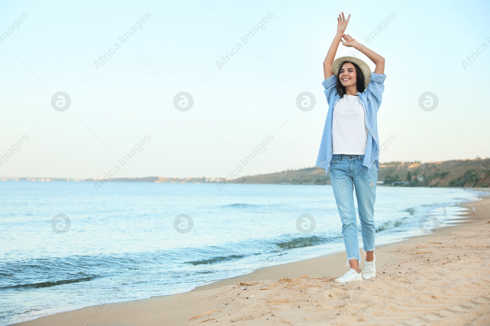 Photo of Beautiful young woman in casual outfit on beach