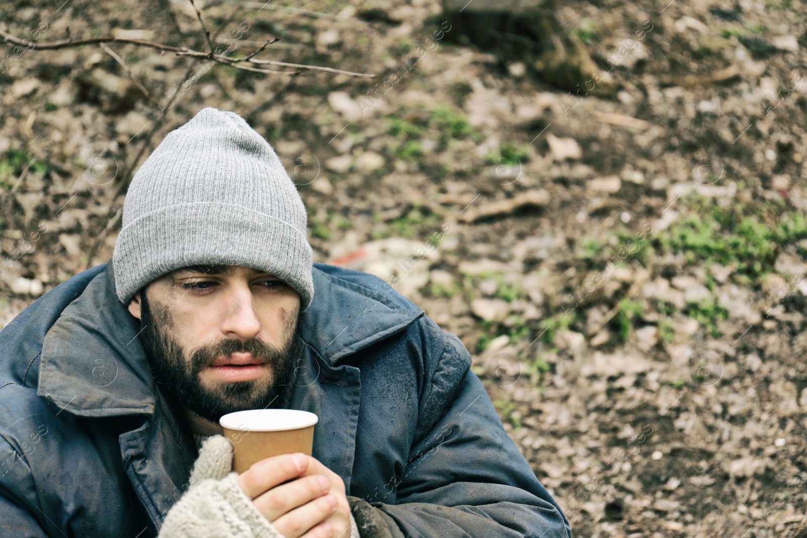 Photo of Poor homeless man with cup in city park