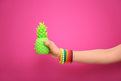 Photo of Woman holding stylish pineapple candle on color background