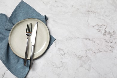 Stylish setting with elegant cutlery on white marble table, top view. Space for text