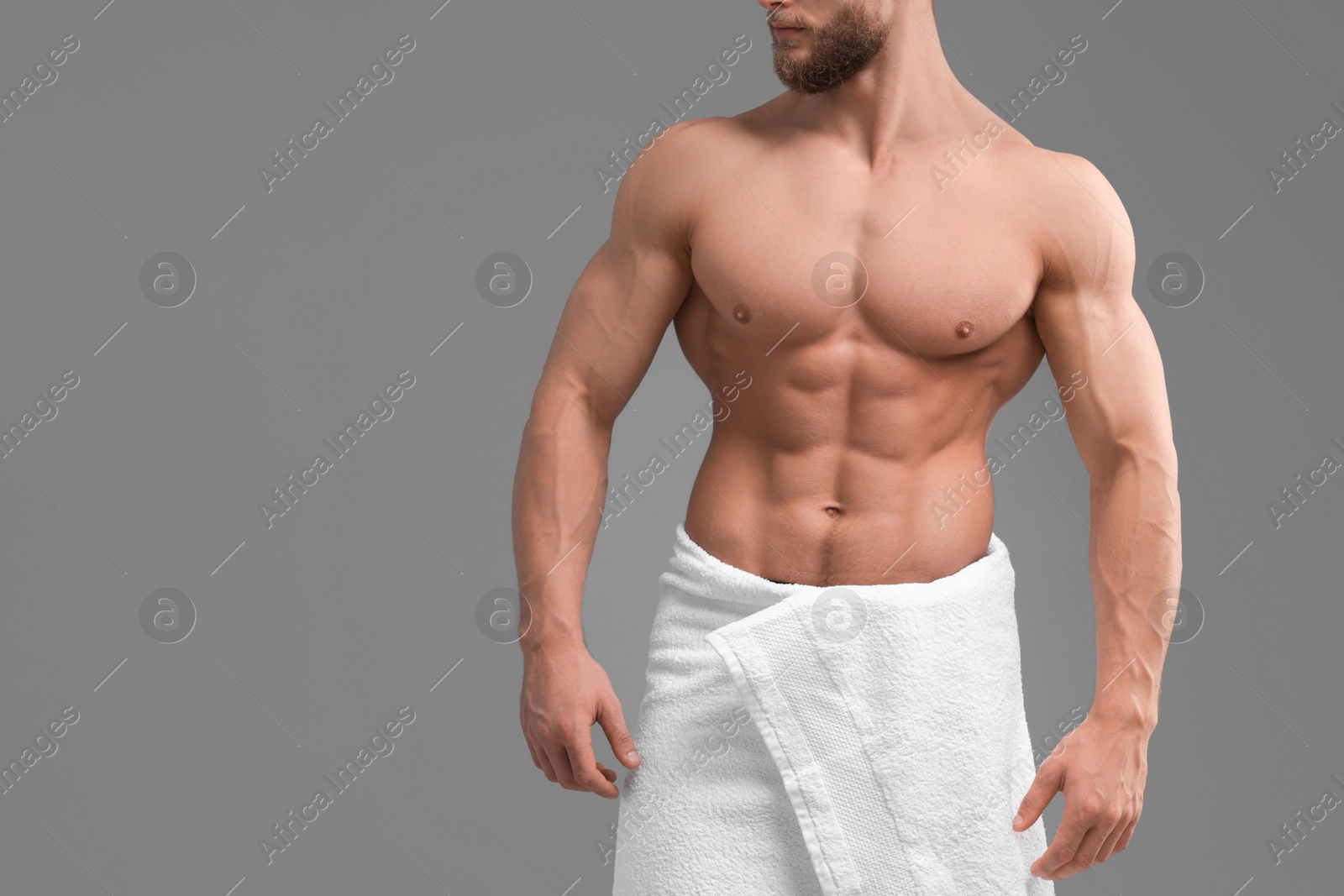 Photo of Muscular man showing abs on light grey background, closeup and space for text. Sexy body