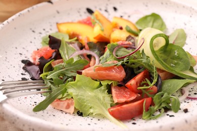 Photo of Delicious salad with vegetables and peach in bowl, closeup