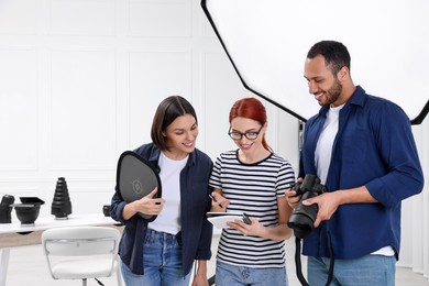 Photo of Young professional photographers working in modern photo studio, space for text