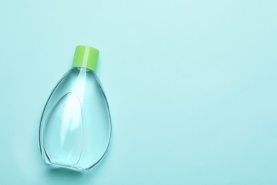 Photo of Bottlebaby oil on turquoise background, top view. Space for text