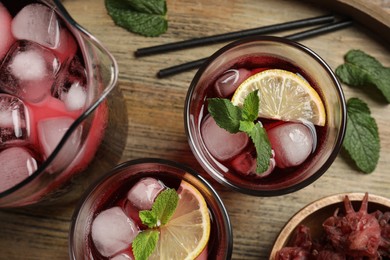 Photo of Delicious iced hibiscus tea with mint on wooden table, flat lay