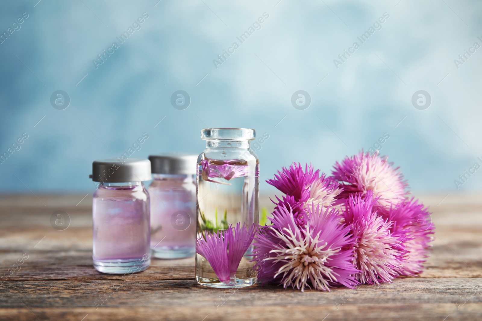 Photo of Composition with essential oils and flowers on table