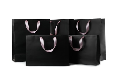 Photo of Paper shopping bags with ribbon handles on white background. Mockup for design