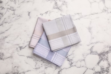 Different handkerchiefs folded on white marble table, flat lay