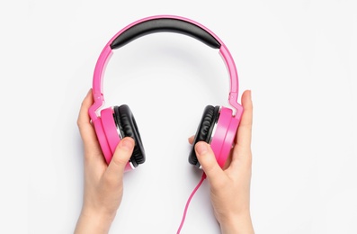 Photo of Woman holding stylish headphones on white background, closeup