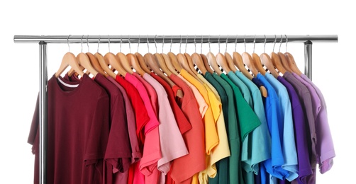 Photo of Rack with rainbow clothes on light background