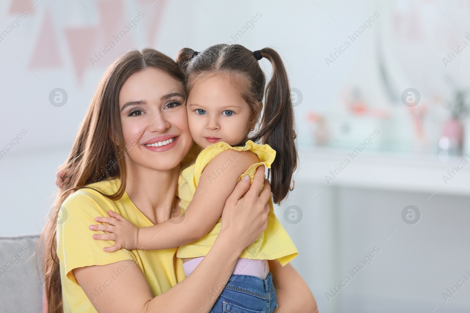 Photo of Young mother with little daughter at home