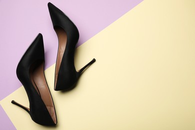 Photo of Pair of elegant black high heel shoes on color background, flat lay. Space for text