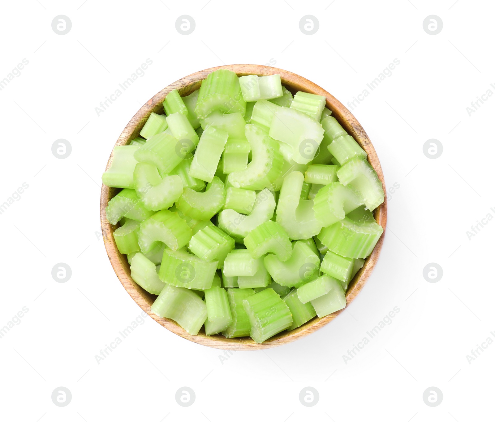 Photo of Wooden bowl of fresh cut celery isolated on white, top view