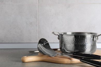 Set of different cooking utensils on grey countertop in kitchen. Space for text