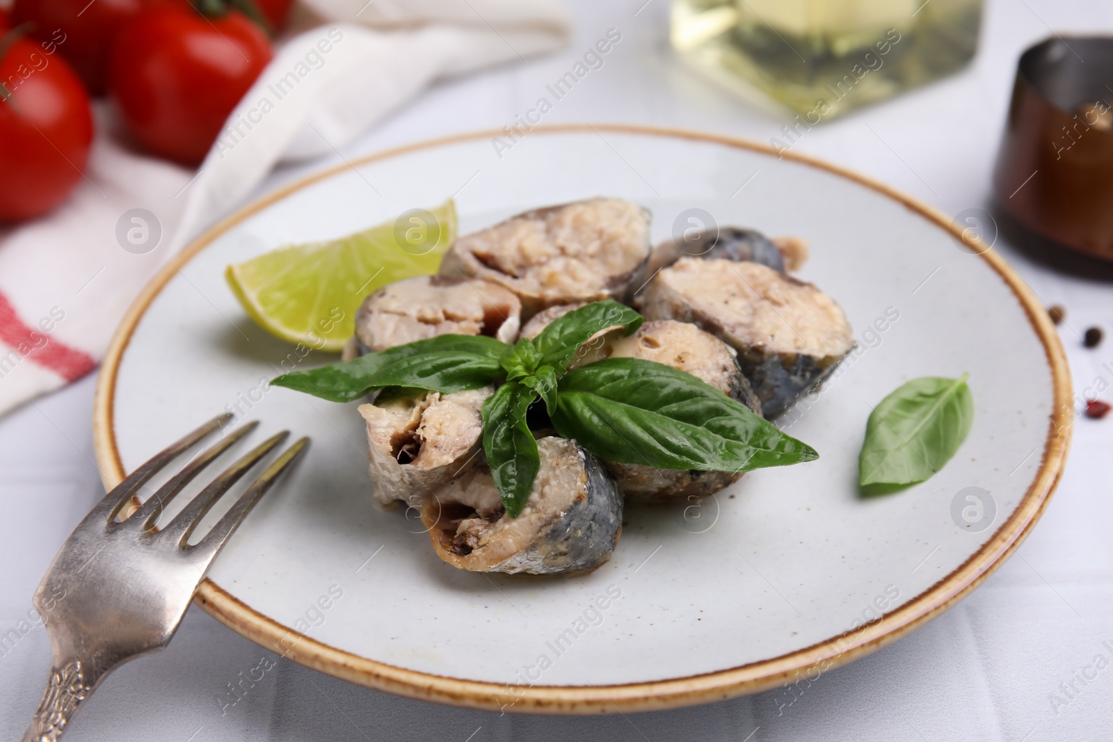Photo of Canned mackerel chunks served on white tiled table, closeup