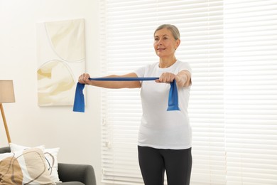 Senior woman doing exercise with fitness elastic band at home