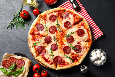 Flat lay composition with hot pepperoni pizza on dark table