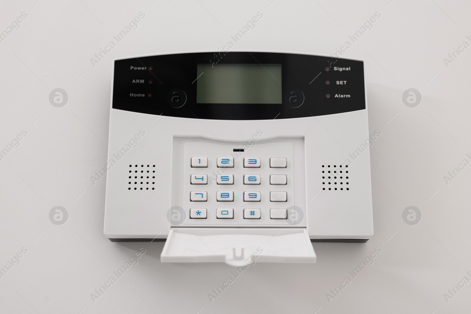 Photo of Home security alarm system on white wall indoors