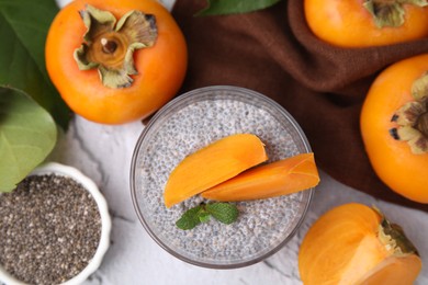 Photo of Delicious dessert with persimmon and chia seeds on table, flat lay