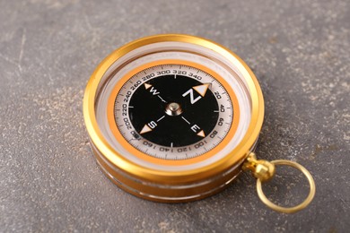One compass on grey textured background, closeup. Navigation equipment