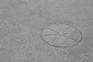 Metal sewer hatch on asphalt outdoors, space for text