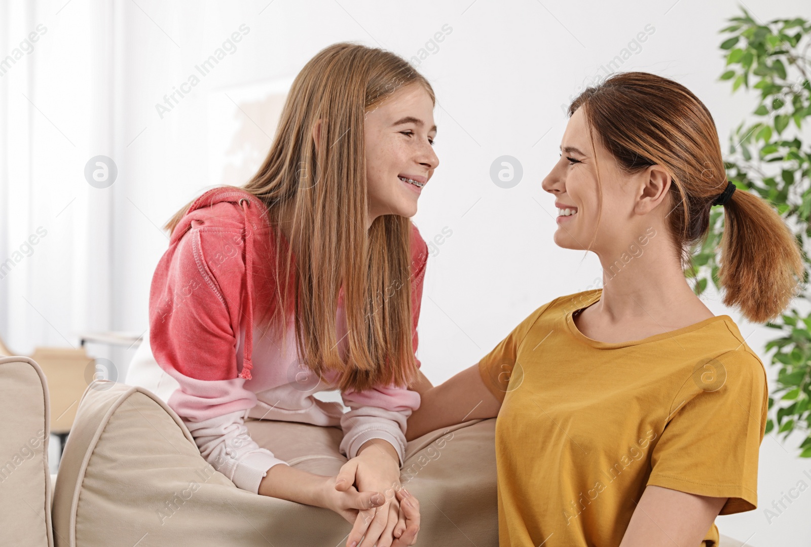 Photo of Young mother talking with her teenager daughter at home