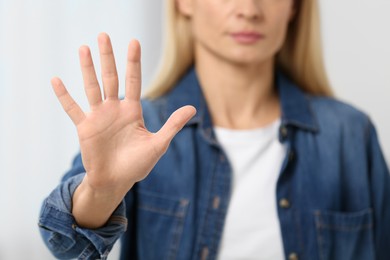 Photo of Woman showing stop gesture on blurred background, closeup