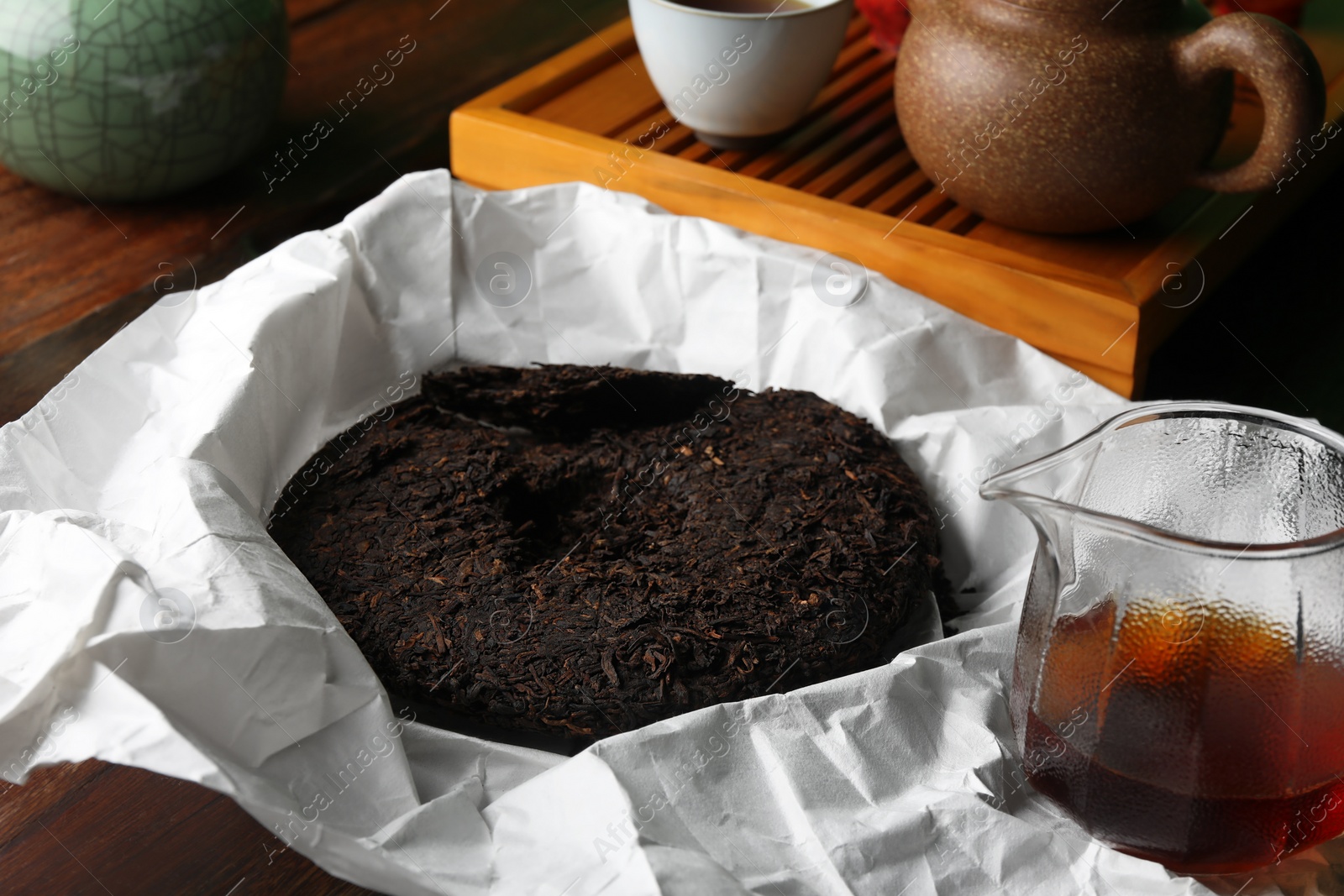 Photo of Aromatic pu-erh on wooden table. Fermented tea