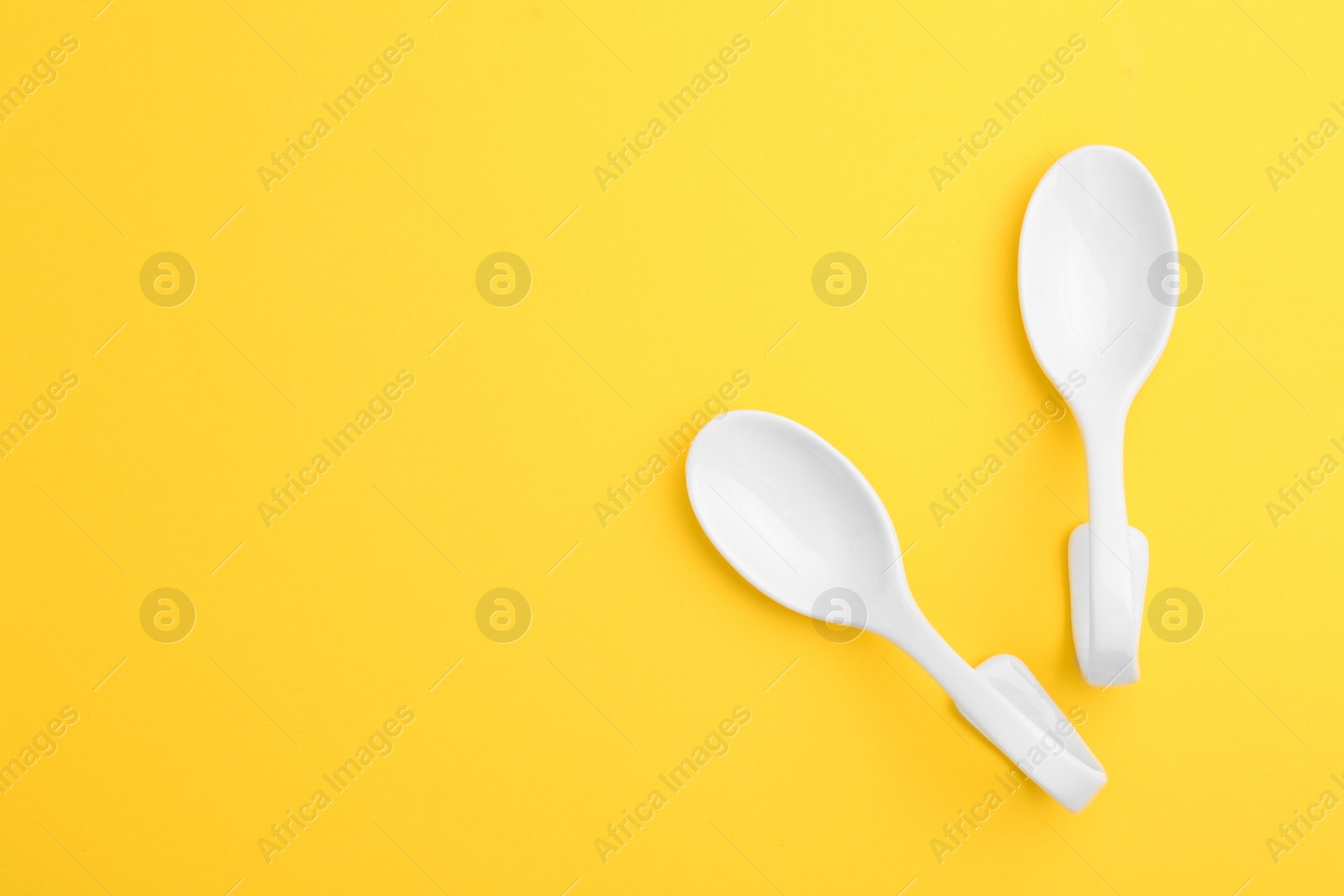 Photo of Clean ceramic appetizer spoons and space for text on color background, flat lay