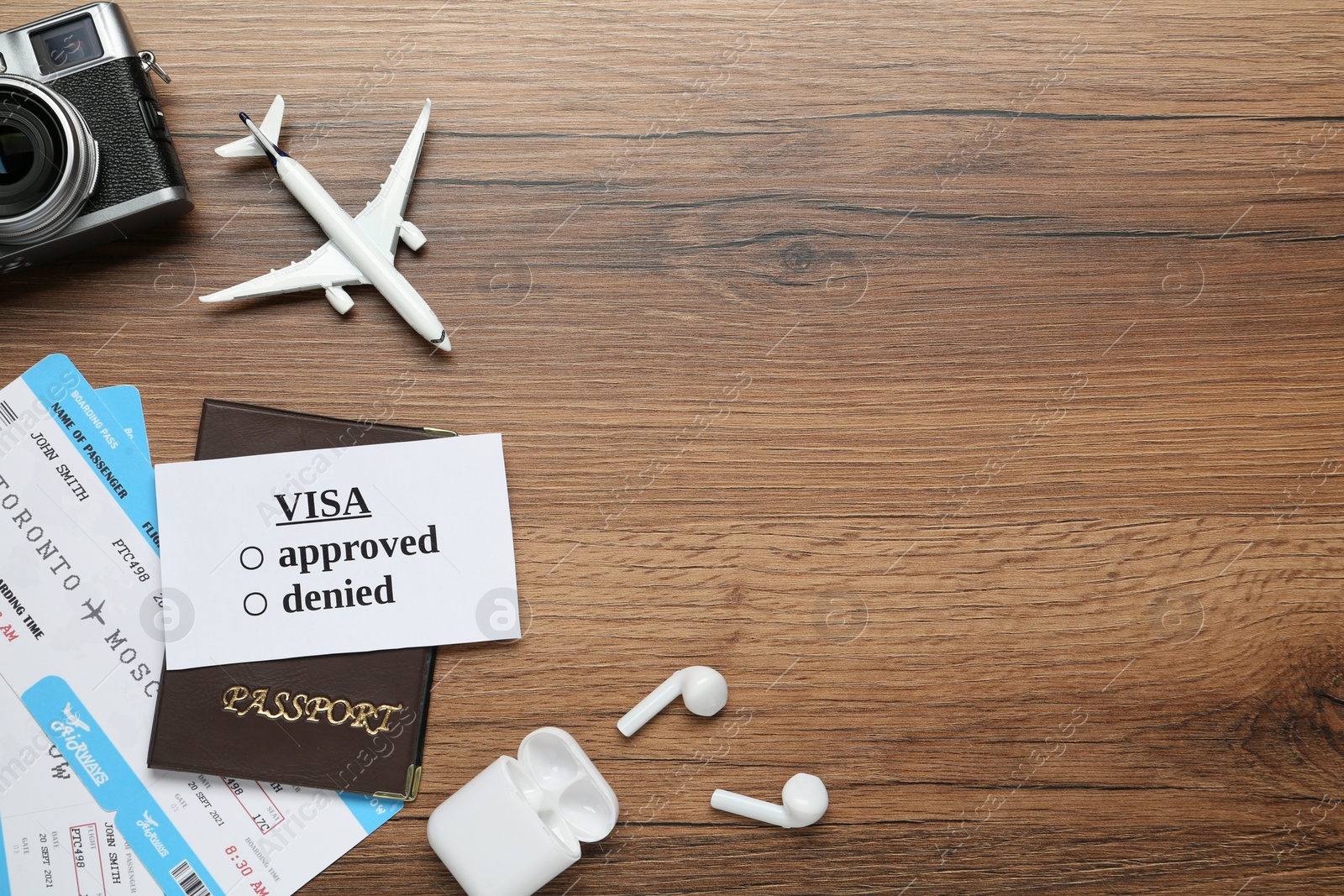 Photo of Flat lay composition with passport, toy plane and tickets on wooden table, space for text. Visa receiving