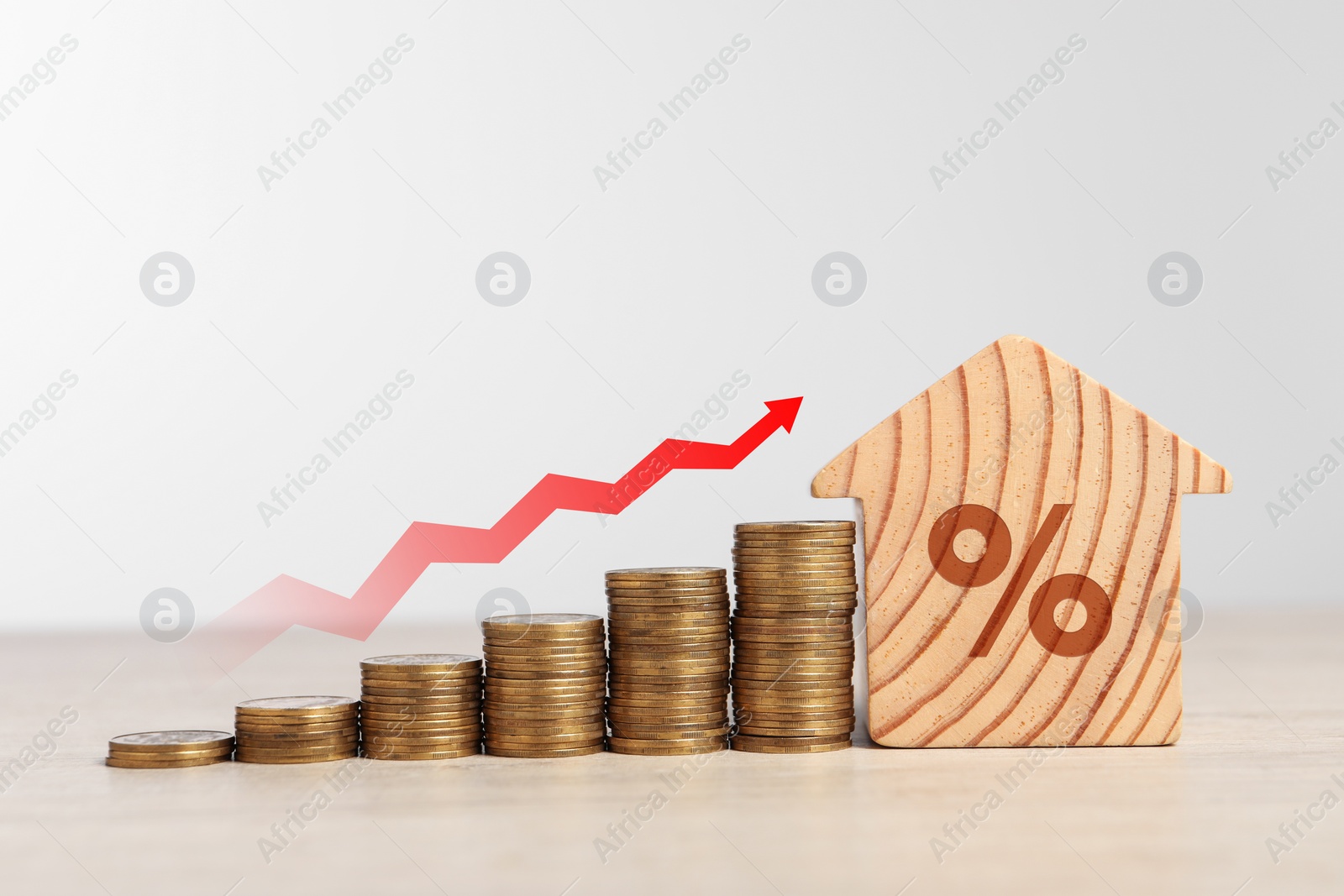 Image of Mortgage rate. Stacked coins, arrow and wooden model of house with percent sign