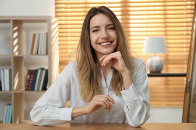 Photo of Young woman holding online webinar indoors, view from webcam